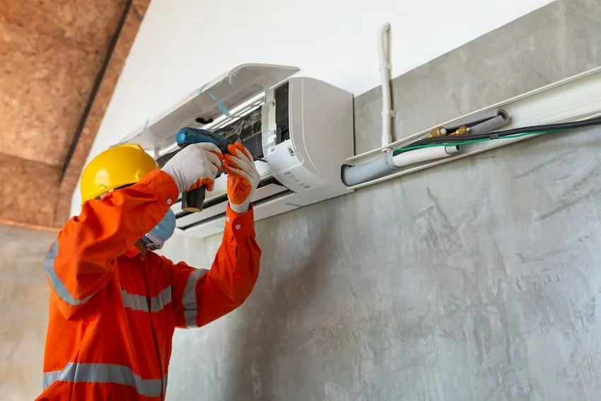 Instalador conectando un aparato de aire acondicionado en una vivienda de Bilbao