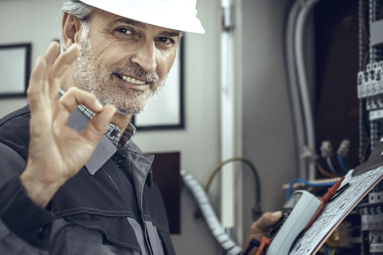 Electricista sujetando un cable con guantes de protección en una instalación eléctrica de un negocio