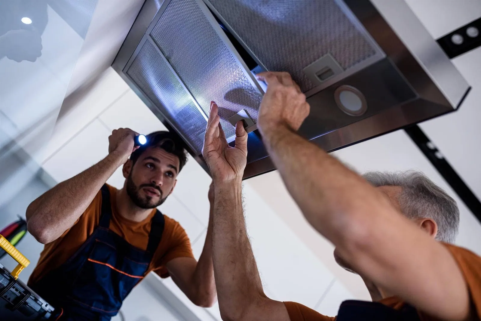 Técnicos montando una campana extractora en la cocina de un piso de Madrid