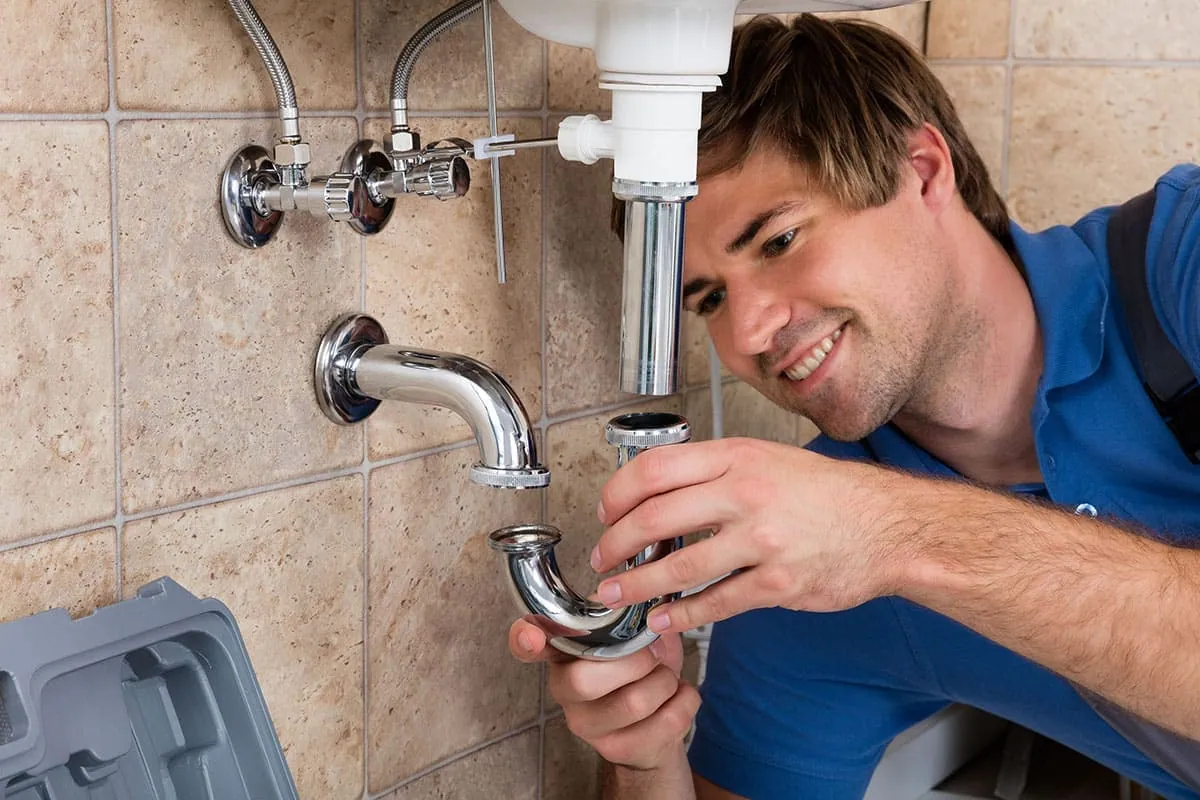 Fontanero instalando la toma de agua de un lavabo en una vivienda de Córdoba