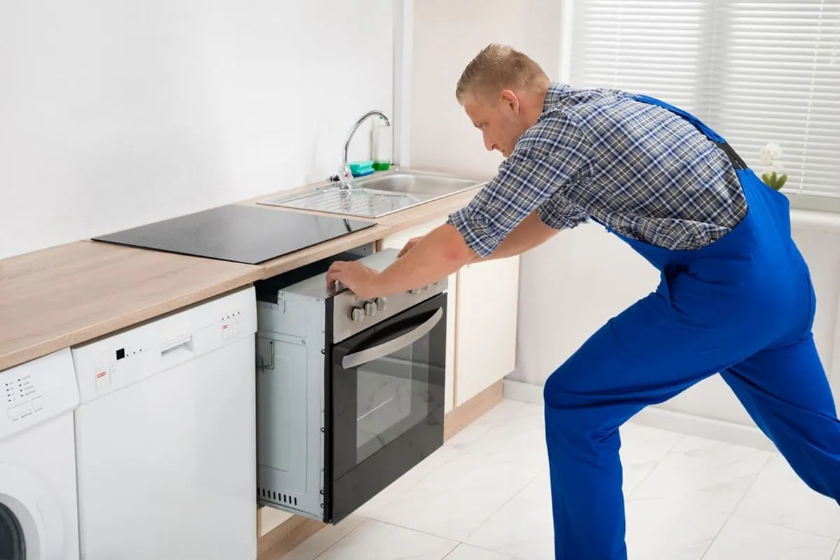 Técnico instalando un horno bajo encimera durante una reparación de hornos a domicilio