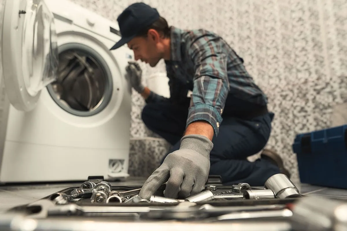 Reparación de una lavadora con herramientas en un negocio con uso continuo