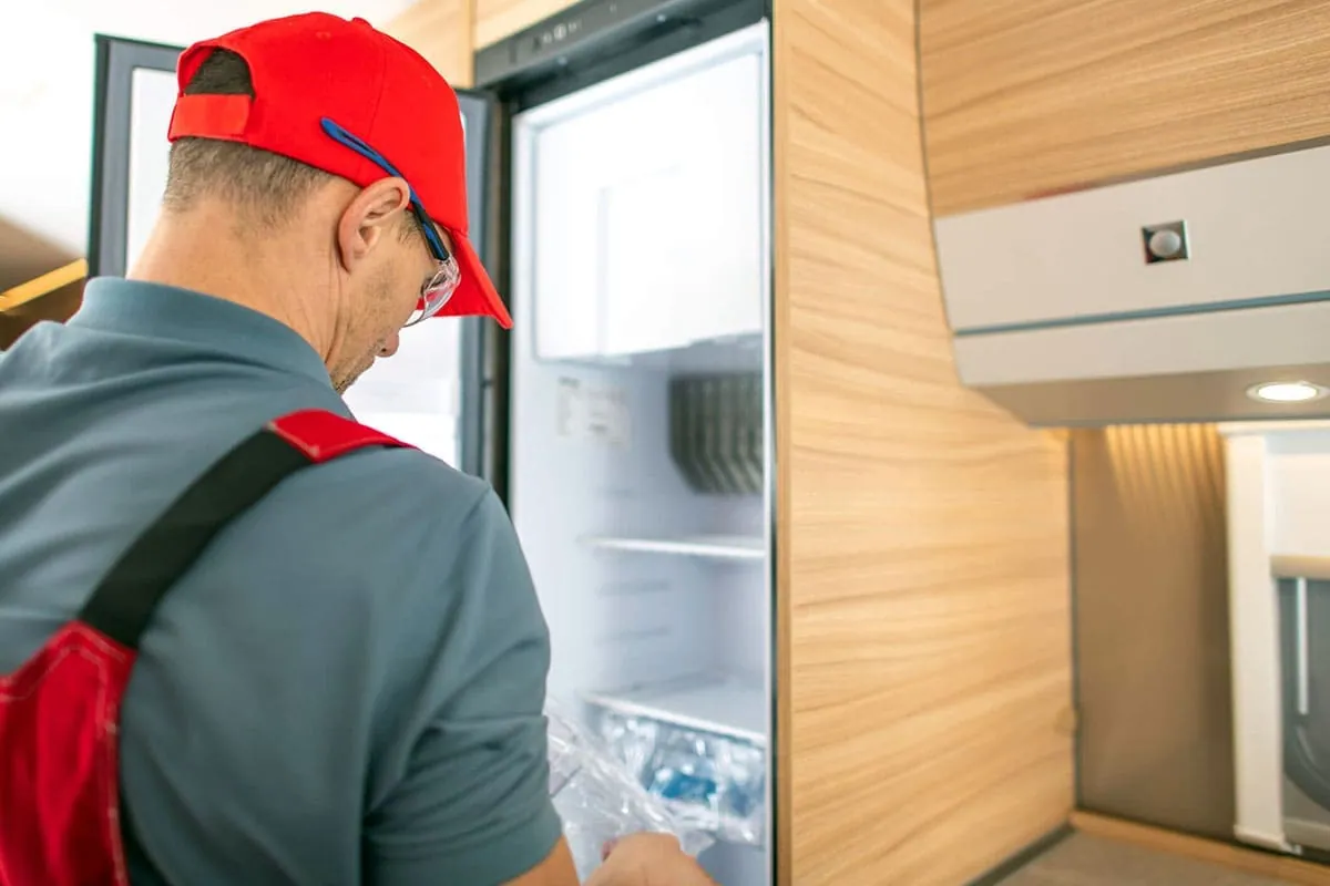 Técnico revisando el interior de una nevera en busca del origen de la avería