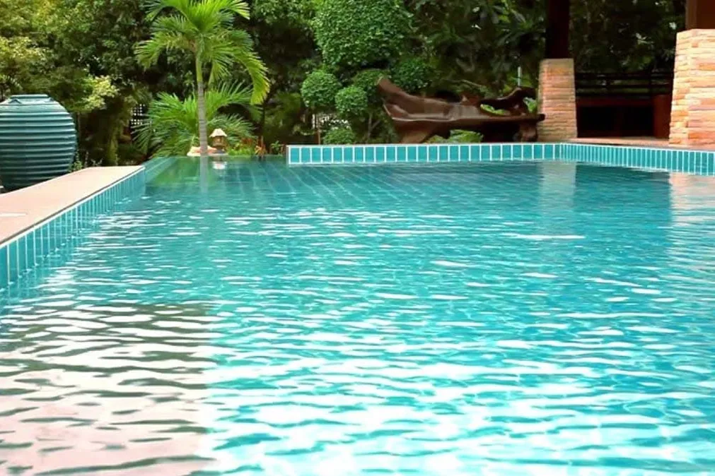 Piscina desbordante con vegetación, un diseño en el que la reparación de fugas empieza por el vaso de compensación