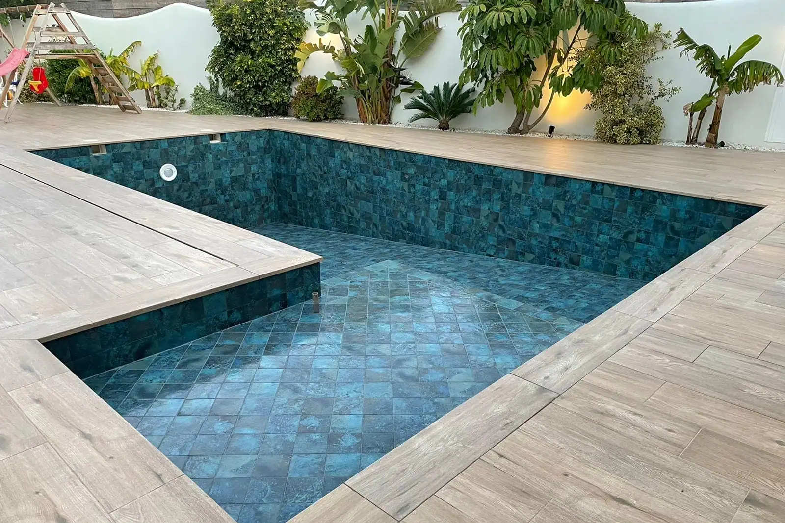 Piscina pequeña de obra con revestimiento de gresite y tarima, un formato práctico en parcelas de Bilbao