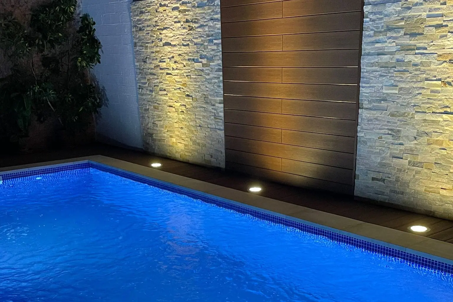 Piscina iluminada de noche con focos sumergidos en una vivienda de Málaga