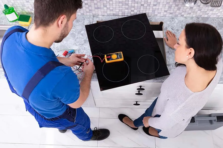 Técnico midiendo una placa de inducción para localizar la avería
