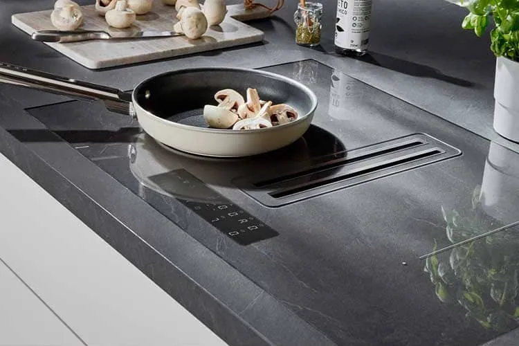 Placa de inducción con una sartén en uso, tras la reparación de inducción en una cocina