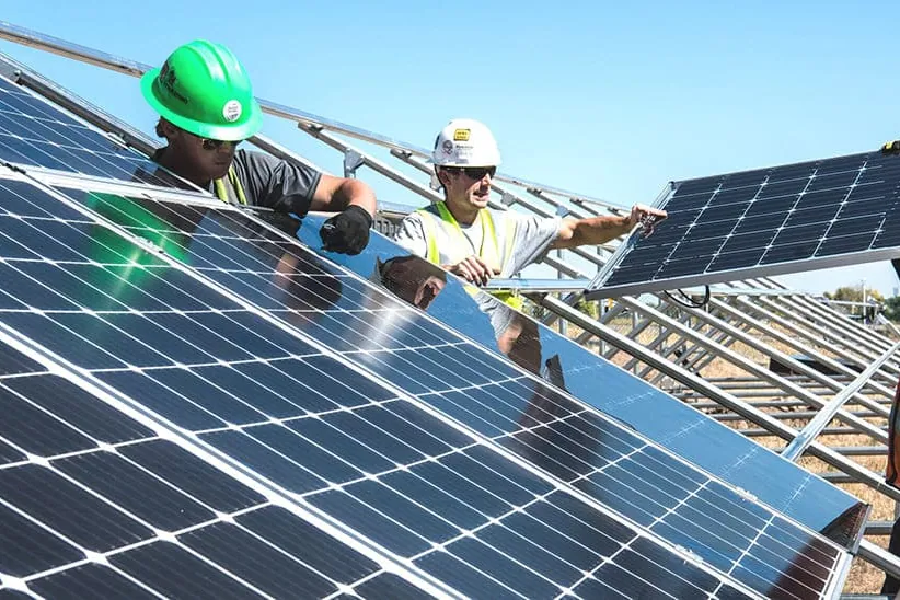 Equipo de instaladores montando una planta de paneles solares para autoconsumo
