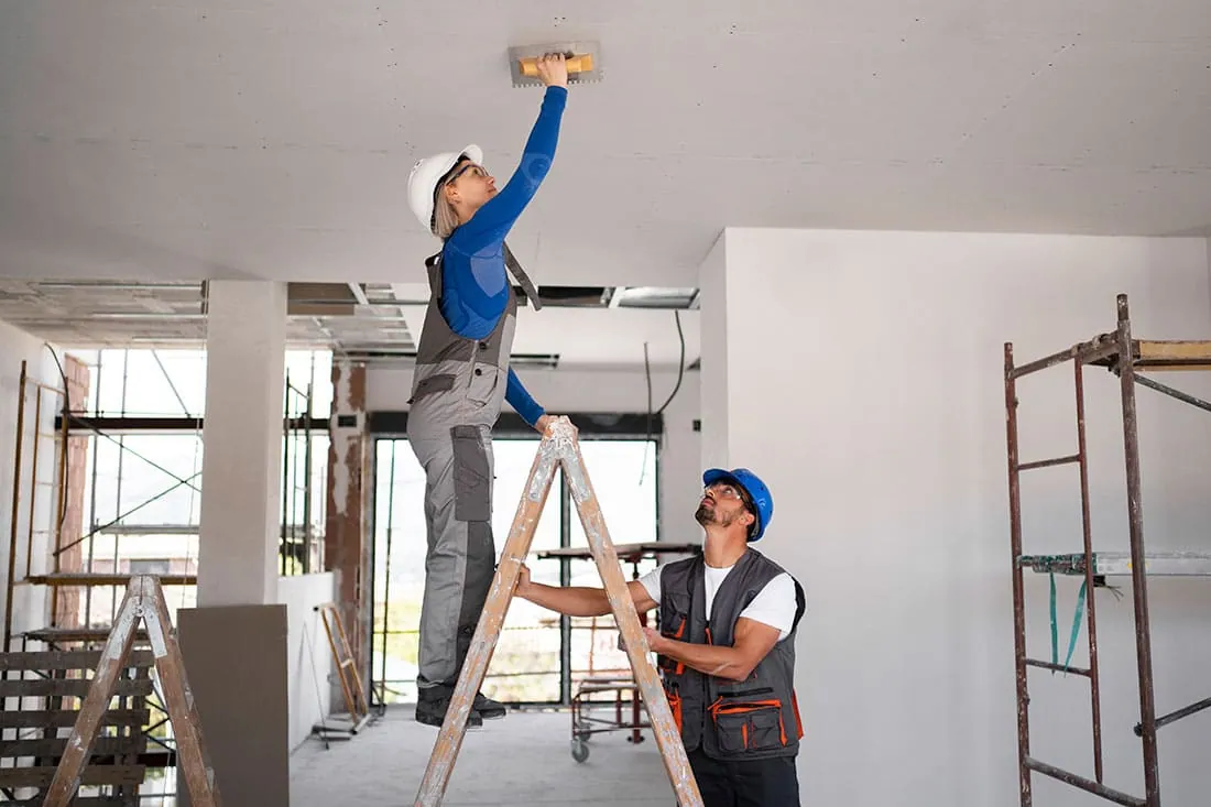 Operarios trabajando en el techo de una vivienda en obras durante unas reformas en Madrid
