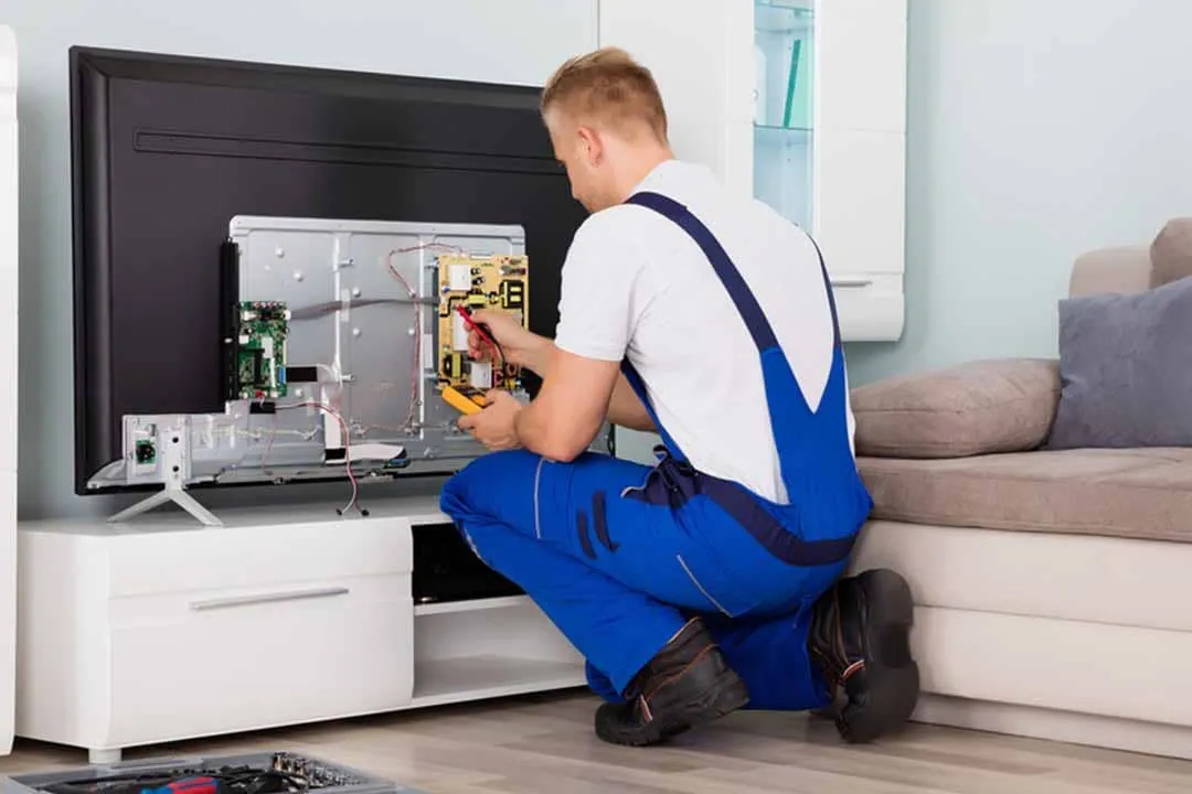 Técnico reparando la parte trasera de un televisor abierto durante una reparación de Smart TV