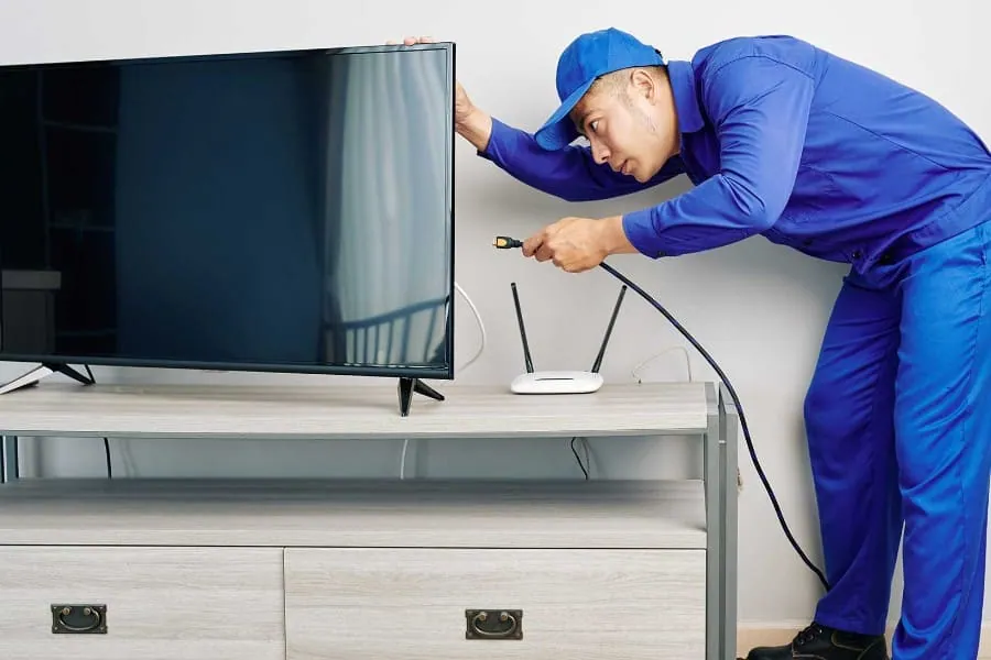 Técnico conectando un televisor durante una reparación de televisores en Granada