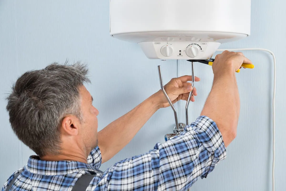 Técnico revisando un termo eléctrico para localizar la pieza averiada antes de repararlo